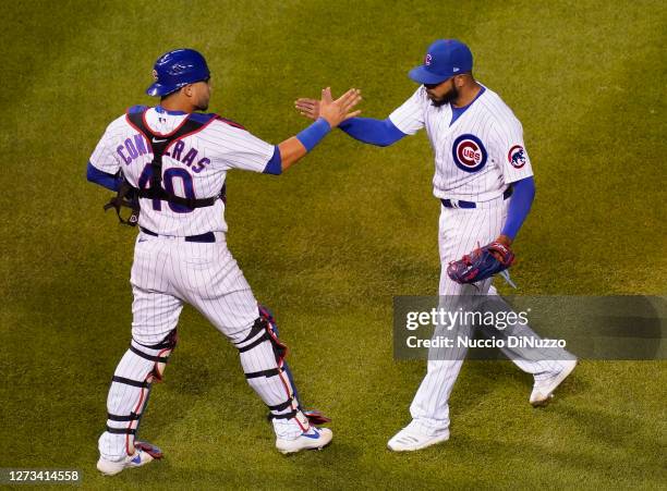 Willson Contreras of the Chicago Cubs and Jeremy Jeffress celebrate at the end of their team's 1-0 win over the Minnesota Twins at Wrigley Field on...