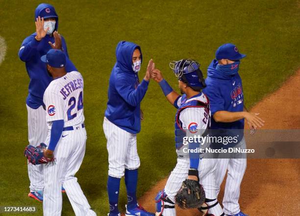 Willson Contreras of the Chicago Cubs and Jeremy Jeffress celebrate with teammates at the end of their team's 1-0 win over the Minnesota Twins at...