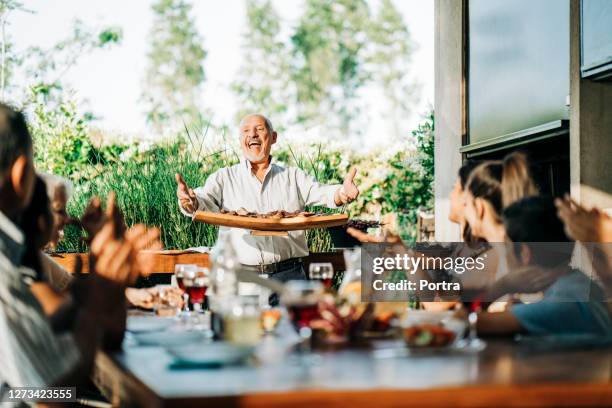 family enjoying weekend party - man tray food holding stock pictures, royalty-free photos & images