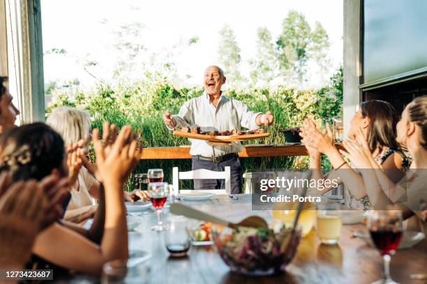 familie genießt gemeinsames wochenende - asado stock-fotos und bilder