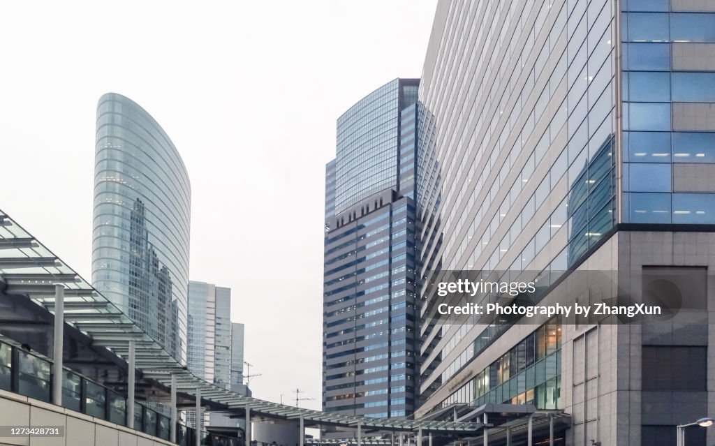 Tokyo city skyline. Business men are walking through modern office buildings at day time.