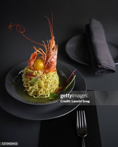 food photography of asian noodles side view with shrimp and lettuce on gray plates in a minimalistic style restaurant serve on a gray background - fine art stock-fotos und bilder