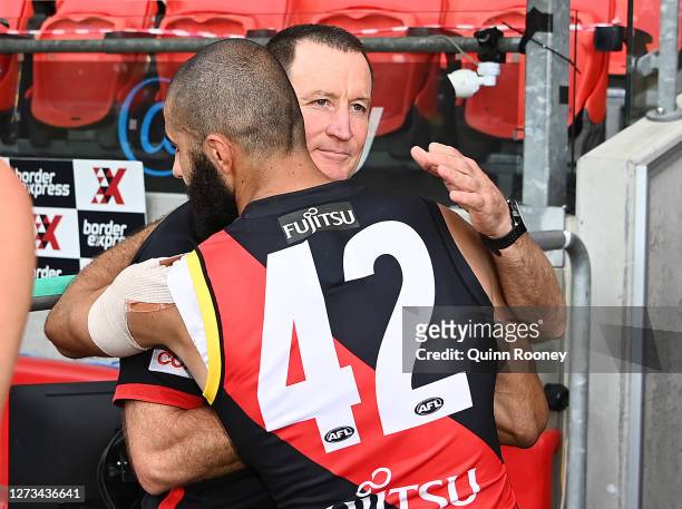 Bombers head coach John Worsfold hugs Adam Saad of the Bombers after coaching in his final game during the round 18 AFL match between the Essendon...