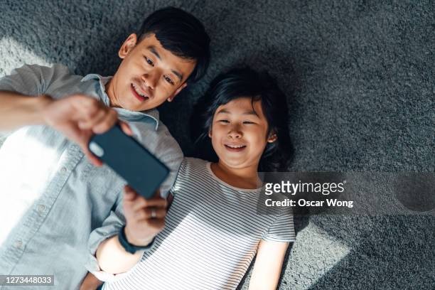 father and daughter having a video call with smart phone - schulkinder eltern stock-fotos und bilder