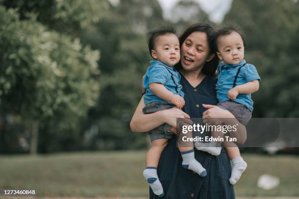 aziatische chinese moeder met haar tweelingjongens bij openbaar park tijdens weekendochtend - asian twins stockfoto's en -beelden