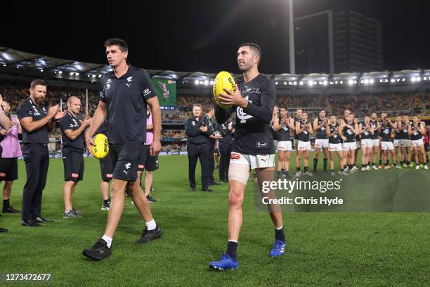 Matthew Kreuzer and Kade Simpson of the Blues leave the field after retiring during the round 18 AFL match between the Brisbane Lions and the Carlton...