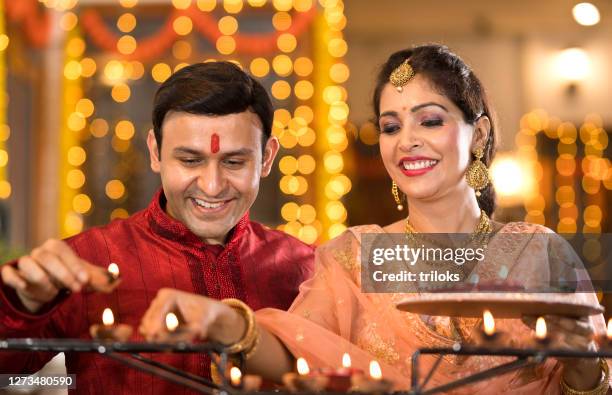 pareja india celebrando festival tradicional - diya oil lamp fotografías e imágenes de stock