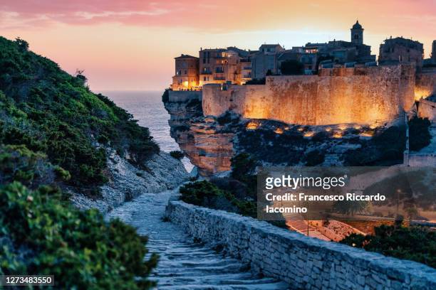 bonifacio, corsica, france. sunset over cliffs and town. - corsica foto e immagini stock