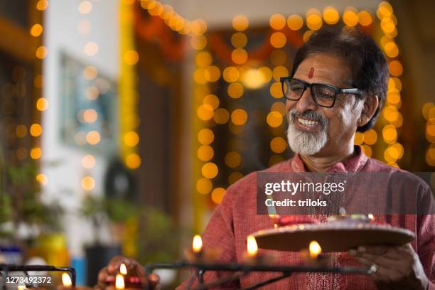 hombre mayor celebrando con motivo del festival diwali - diya oil lamp fotografías e imágenes de stock