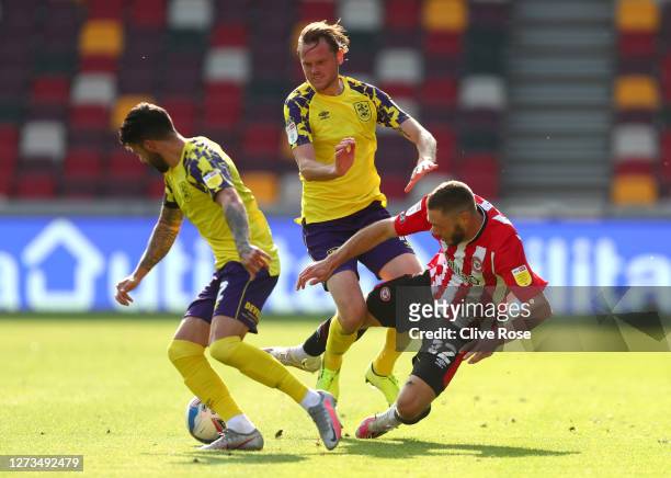 Henrik Dalsgaard of Brentford is brought down by Jacob Chapman of Huddersfield Town during the Sky Bet Championship match between Brentford and...