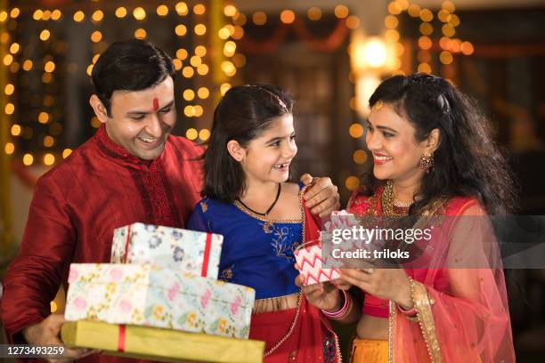 happy couple surprise gifts for daughter celebrating traditional indian diwali festival - diwali family stock pictures, royalty-free photos & images