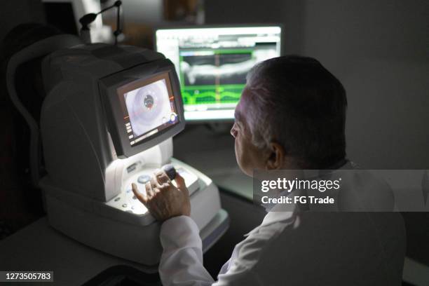 ophthalmologist analyzing exam's results in a monitor - retinal scan stock pictures, royalty-free photos & images