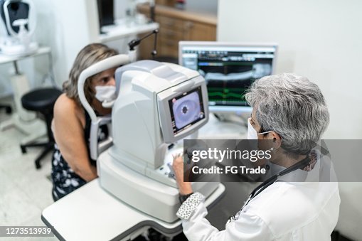 Optometrist examing patient's eyes Optometrist examing patient's eyes