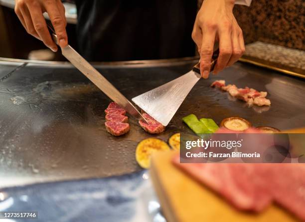 a chef prepares teppanyaki in kobe - teppanyaki stock pictures, royalty-free photos & images