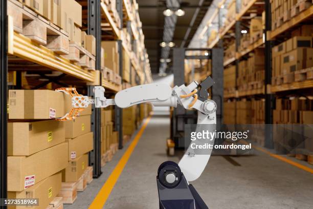 robotic arm taking a cardboard box in the warehouse - robot stock pictures, royalty-free photos & images