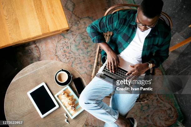 aerial view of a young african american man working on his laptop - laptop overhead view stock pictures, royalty-free photos & images
