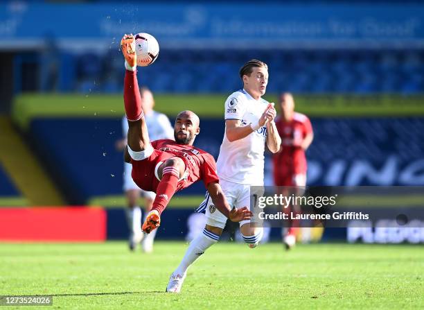 Denis Odoi of Fulham makes an overhead kick under pressure from Ezgjan Alioski of Leeds United during the Premier League match between Leeds United...