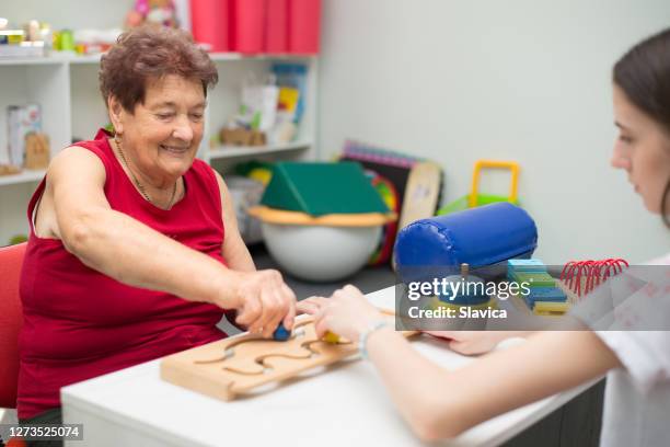 alte frau auf physiotherapie - ordination stock-fotos und bilder