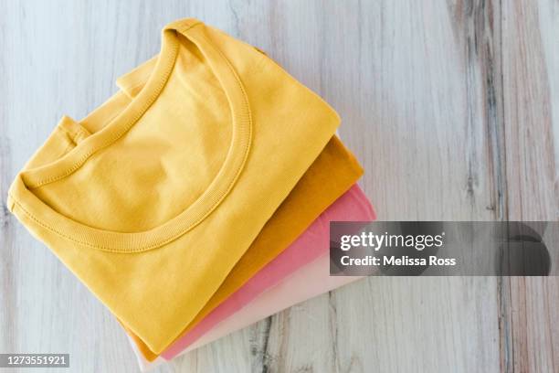 stack of cotton t-shirts - ropa doblada fotografías e imágenes de stock