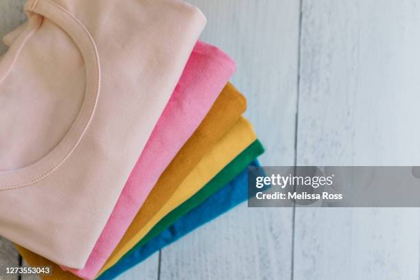 stack of colorful t-shirts - folded tee stock pictures, royalty-free photos & images