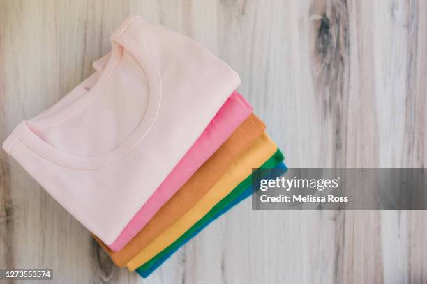 stack of colorful t-shirts - camisa de colores fotografías e imágenes de stock