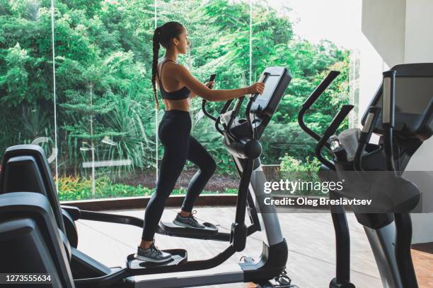 woman training on stepper or treadmill in fitness club of gym. side view. power and endurance functional cardio training. woman health. - kardiovaskulär träning bildbanksfoton och bilder