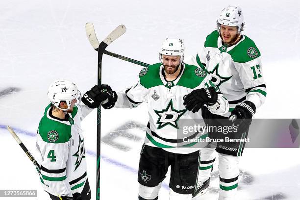 Jason Dickinson of the Dallas Stars is congratulated by Miro Heiskanen and Mattias Janmark after scoring an empty-net goal against the Tampa Bay...