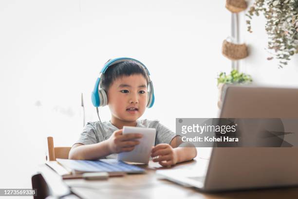 boy taking an e-learning course at home - kids learning at home ストックフォトと画像