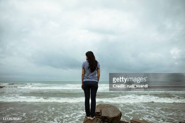 droevige en eenzame vrouw die zich voor de indische oceaan bevindt - woman front and back stockfoto's en -beelden