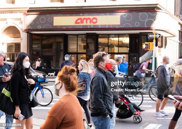 People wear protective face masks outside AMC 19th St. East 6 movie theater as the city continues Phase 4 of re-opening following restrictions...