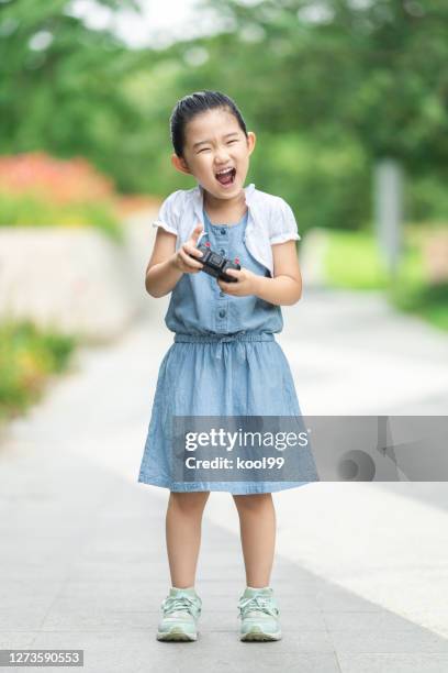 leuk meisje dat met afstandsbedieningsspeelgoed met de afstandsbediening speelt - remote controlled car stockfoto's en -beelden