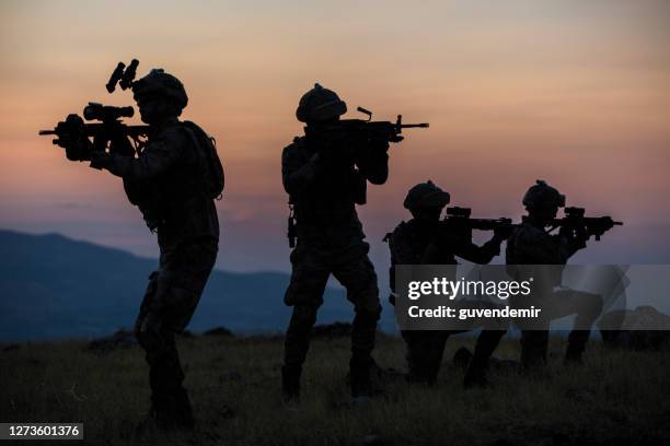 military silhouettes fighting scene on war with twilight background - fight for the troops stock pictures, royalty-free photos & images