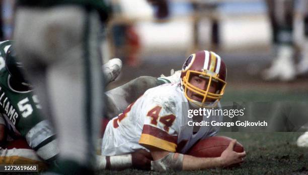 Running back John Riggins of the Washington Redskins looks up from the ground after he was tackled by linebacker Joel Williams of the Philadelphia...