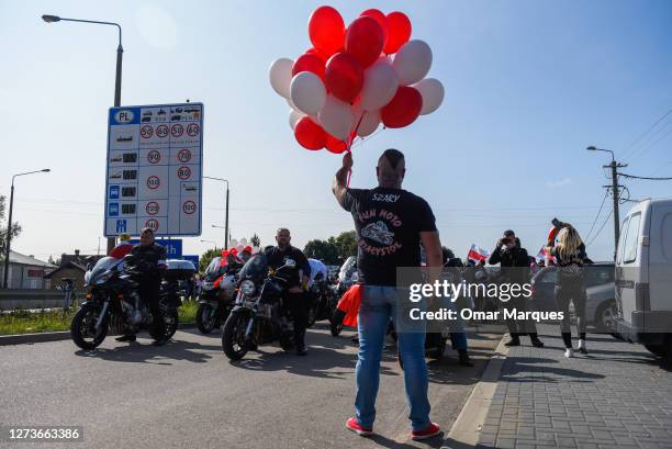 Man holds red and white balloons as he takes part in the "Highway to Freedom", a solidarity march for Belarus finishing at the Polish-Belarusian...