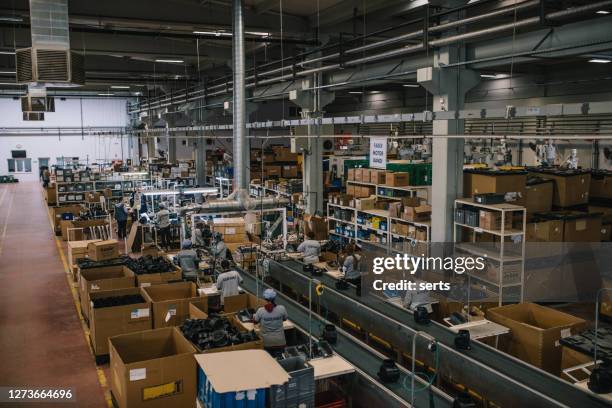 electronics industry workers working with manufacturing equipment in a factory - labor intensive production line stock pictures, royalty-free photos & images