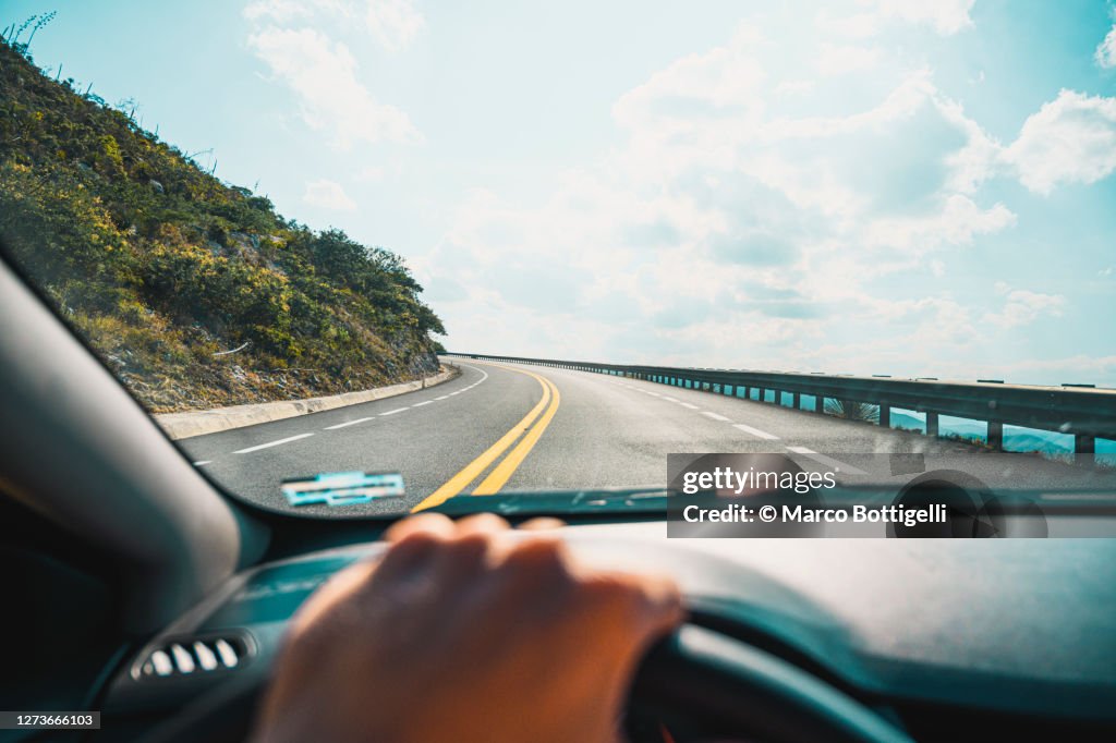 Personal perspective of person driving on mountain road