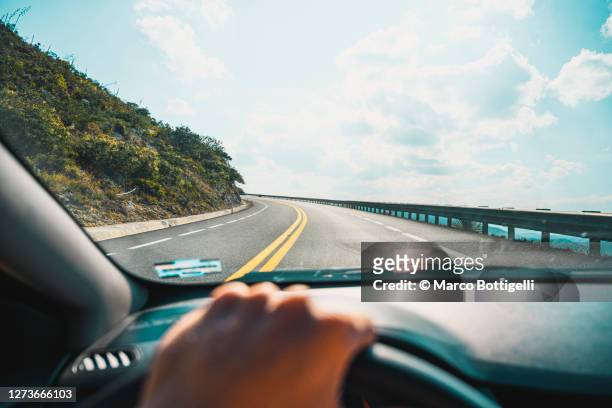 personal perspective of person driving on mountain road - rijden een motorvoertuig besturen stockfoto's en -beelden