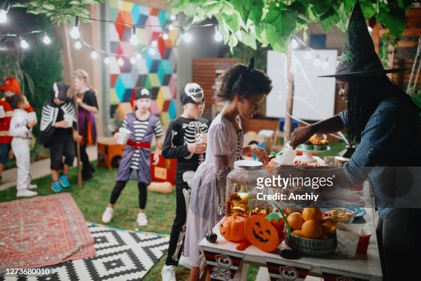 父母在後院電影之夜為她的孩子和他們的朋友提供糖果和爆米花。 - halloween party 個照片及圖片檔