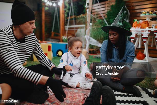 parents telling scary stories to kids at outdoor halloween party - halloween covid stock pictures, royalty-free photos & images