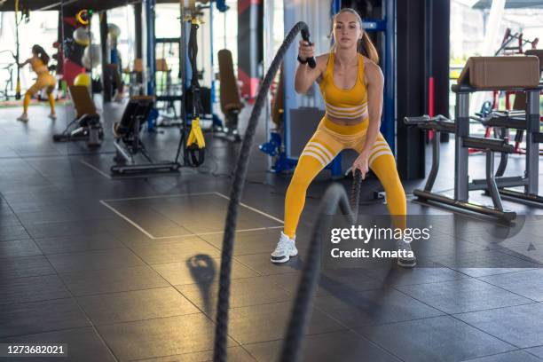 woman doing battle rope exercise in gym. - battle rope stock pictures, royalty-free photos & images