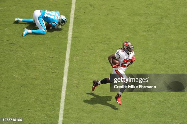 Ronald Jones of the Tampa Bay Buccaneers runs on his way to scoring a first quarter touchdown after stiff arming Juston Burris of the Carolina...