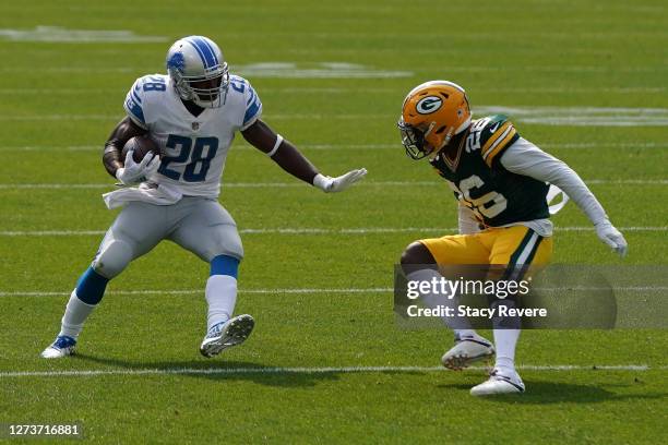 Adrian Peterson of the Detroit Lions avoids a tackle by Darnell Savage of the Green Bay Packers during the first quarter at Lambeau Field on...