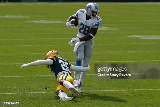 Adrian Peterson of the Detroit Lions avoids a tackle by Darnell Savage of the Green Bay Packers during the first quarter at Lambeau Field on...