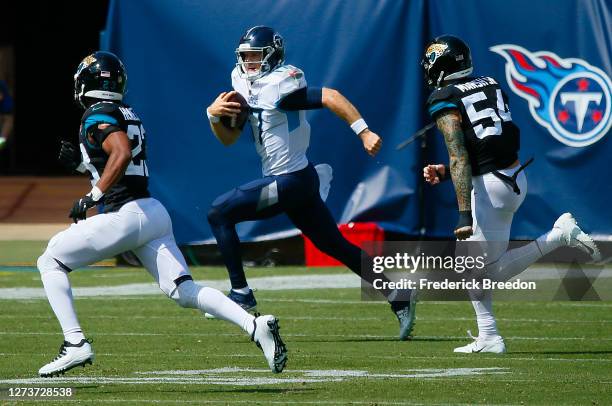 Quarterback Ryan Tannehill of the Tennessee Titans rushes past Cassius Marsh of the Jacksonville Jaguars during the first half at Nissan Stadium on...