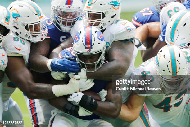 Devin Singletary of the Buffalo Bills is tackled by Davon Godchaux of the Miami Dolphins during the first half at Hard Rock Stadium on September 20,...