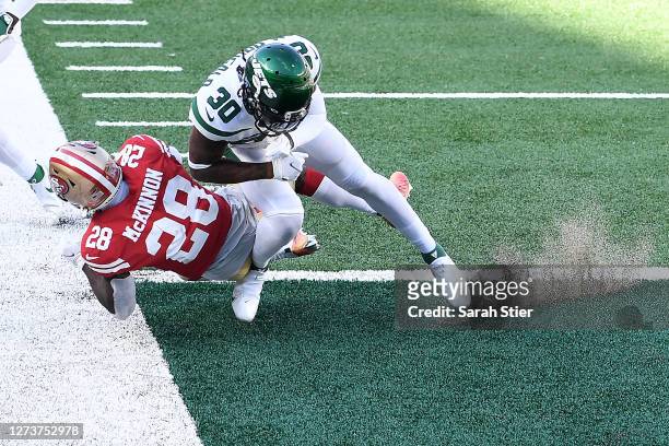 Jerick McKinnon of the San Francisco 49ers scores a touchdown as Bradley McDougald of the New York Jets defends during the second half at MetLife...