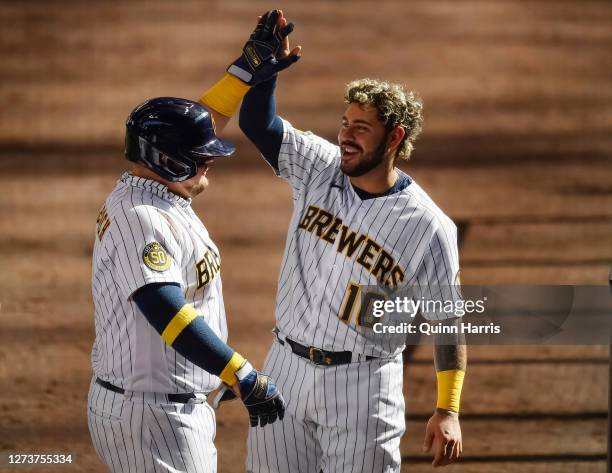 Omar Narvaez of the Milwaukee Brewers congratulates Daniel Vogelbach of the Milwaukee Brewers for his three run home run in the sixth inning against...