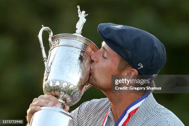 Bryson DeChambeau of the United States kisses the championship trophy in celebration after winning the 120th U.S. Open Championship on September 20,...