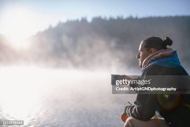 hiker drinking coffee at sunrise around the lake at sunrise. - zen-like stock pictures, royalty-free photos & images