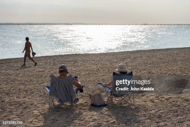 Couple sit on the beach in the late afternoon during the recent warm weather on September 20, 2020 in Southend on Sea, London.